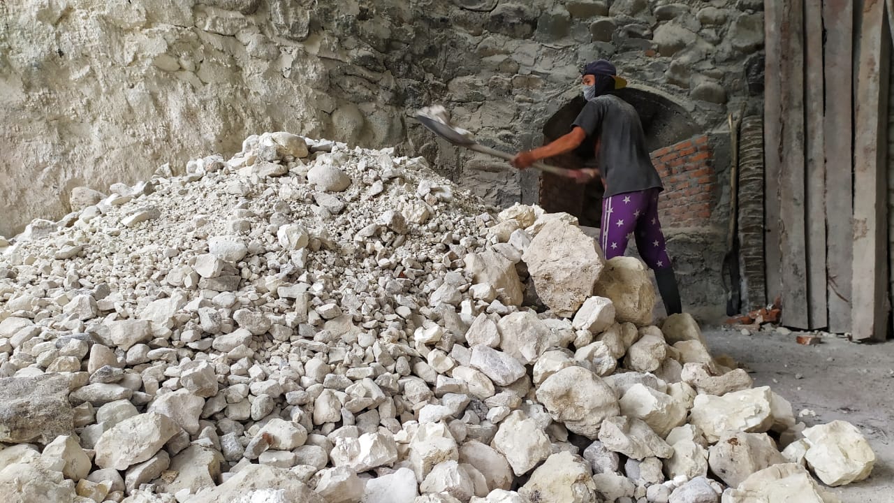 Pekerja sedang mengeluarkan batu dari tungku. (Foto: Marshal D.)