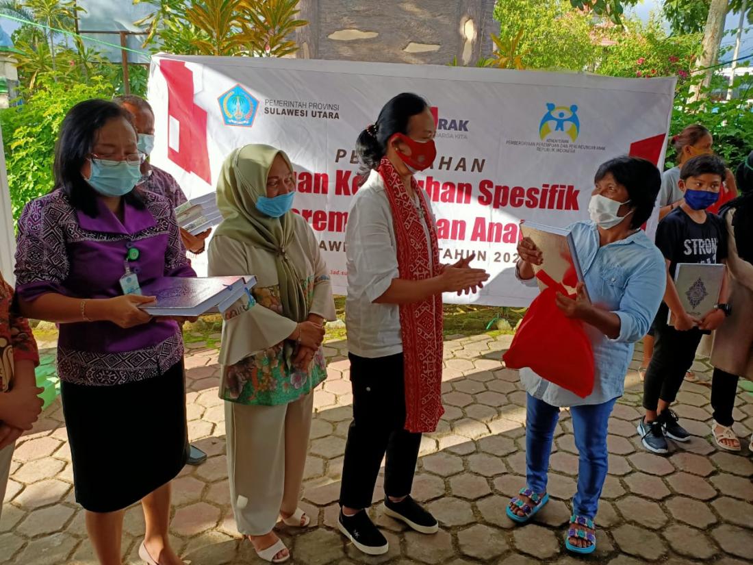 Kepala Dinas Pemberdayaan Perempuan dan Perlindungan Anak Provinsi Sulawesi Utara, Mieke Pangkong menyerahkan secara simbolis kepada perempuan terdampak Covid-19 dan korban KDRT. (Foto: Kominfo Kotamobagu)