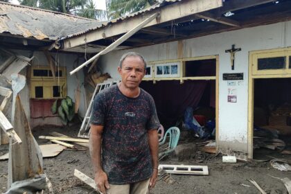Edwin Ambar (59), warga Desa Laingpatehi saat memeriksa keadaan rumahnya, usai erupsi Gunung Ruang, (Foto: ZONAUTARA.com/Gitta Waloni).