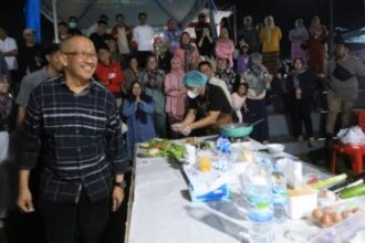 Pj. Wali Kota Kotamobagu, Asripan Nani saat ikut berpartisipasi dalam lomba masak nasi goreng, (Foto: Diskominfo KK).