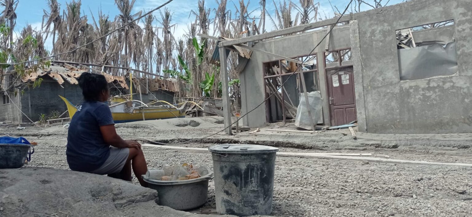 Bersama barang yang berhasil ditemukannya, Alfrida duduk menatap rumah yang iabangun bersama almarhum suaminya, (Foto: ZONAUTARA.com/Neno Karlina).