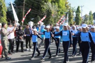 Pj wali kota kotamobagu resmi melepas peserta lomba gerak jalan hut ke-17 kota kotamobagu, (foto: diskominfo kk).