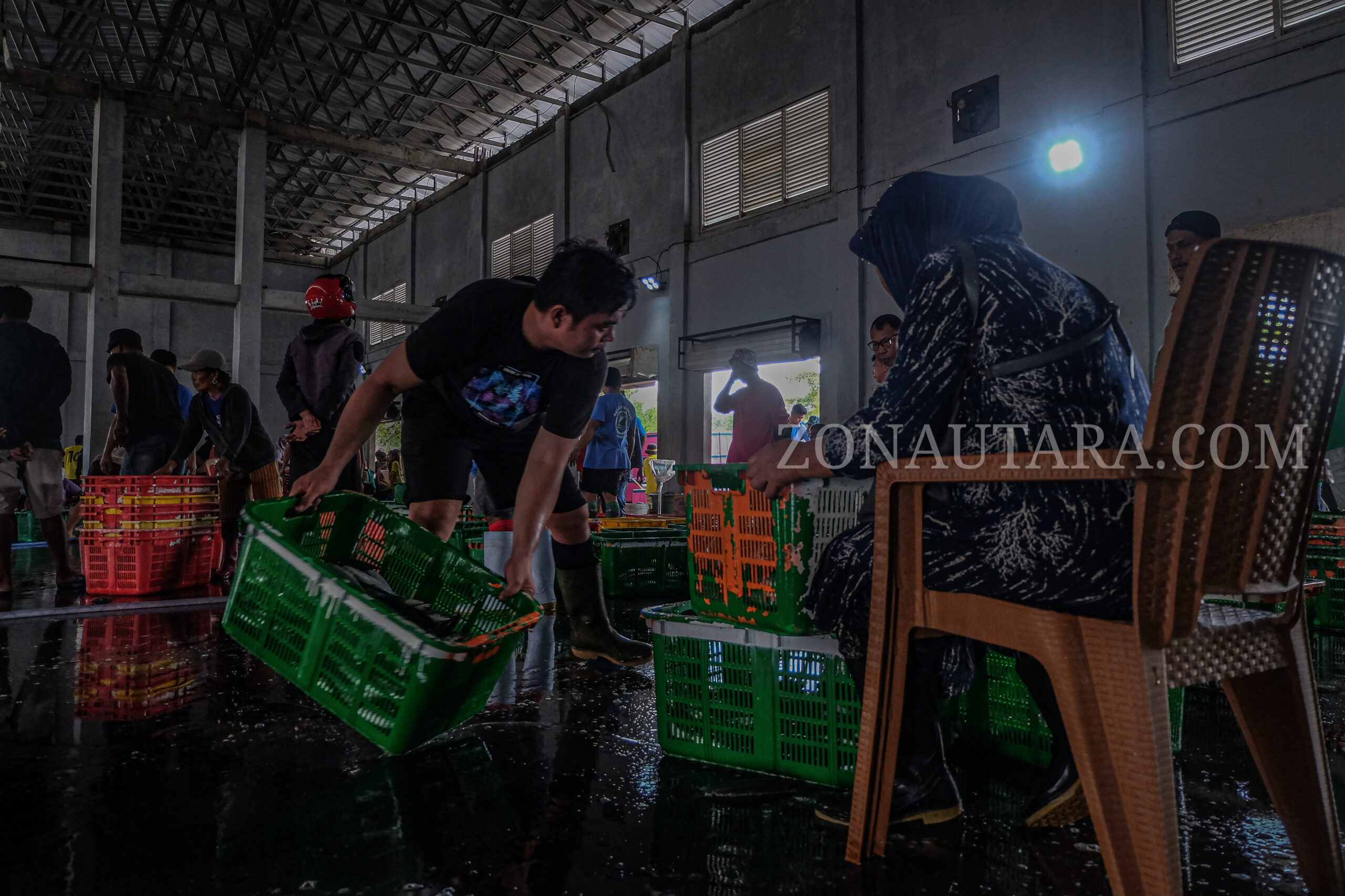 Para nelayan sedang menyortir ikan-ikan yang rusak dan bagus untuk di timbang