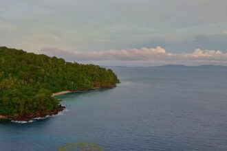 Dari bukit savana, terlihat jelas pemandangan Pantai Pulisan yang menghampar luas, (Foto: ZONAUTARA.com/Tonny Rarung).