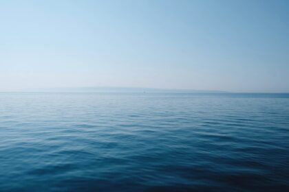 body of water under blue and white sky at daytime